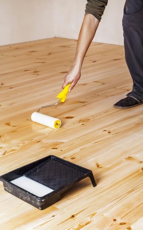 varnishing-wooden-floor-with-roller_203337-1986